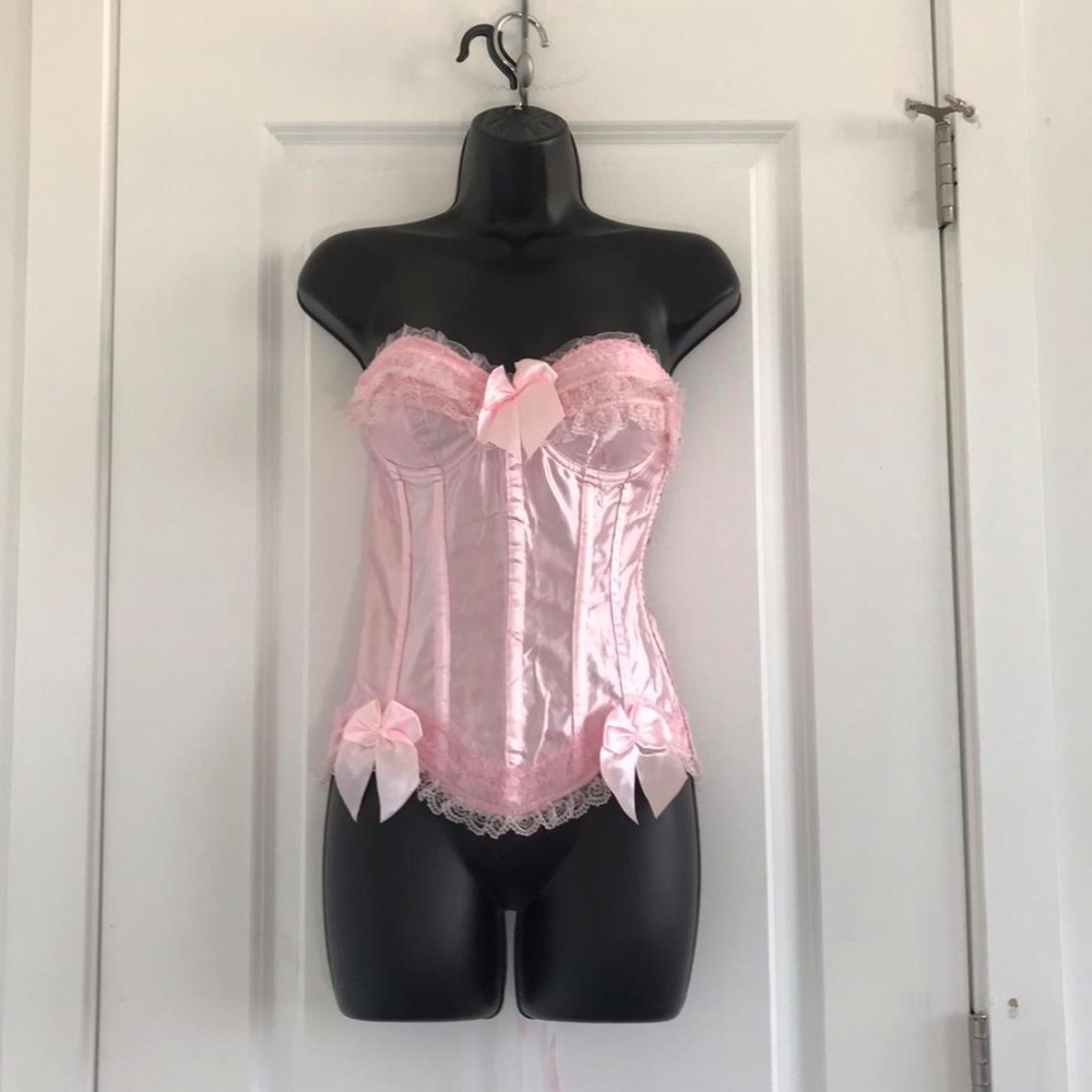 A pink corset top with a pink bow